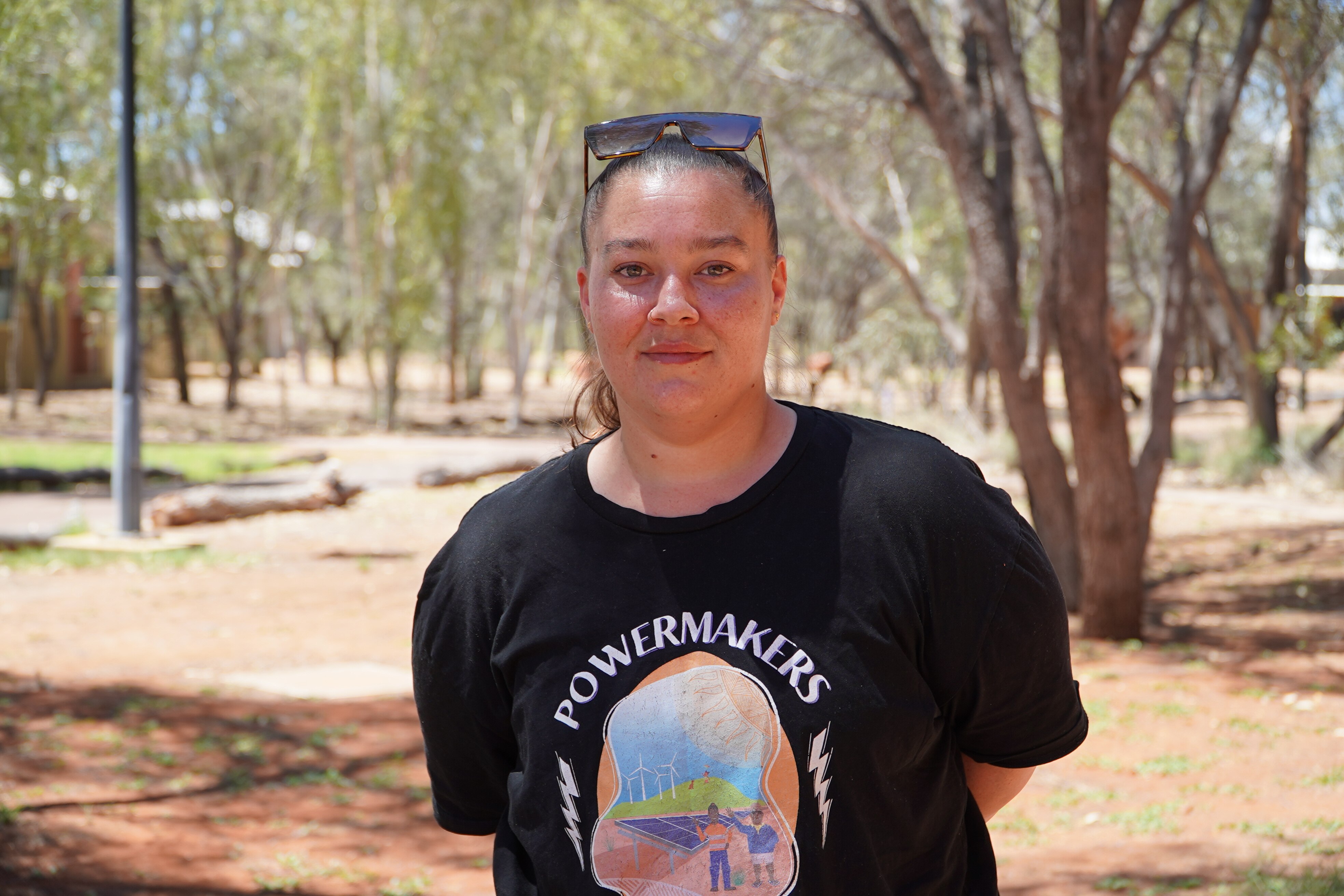 Una mujer con gafas de sol en la cabeza mira a la cámara.