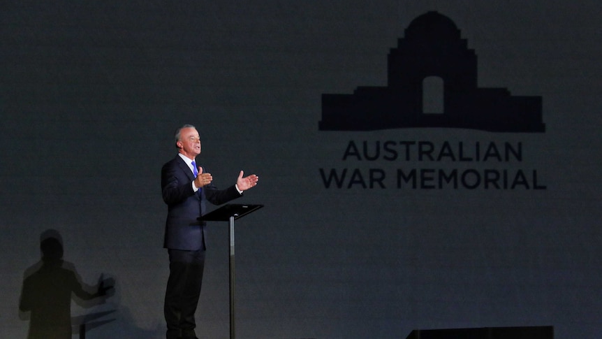Brendan Nelson speaks at a lectern with the Australian War Memorial logo projected on a wall nearby.
