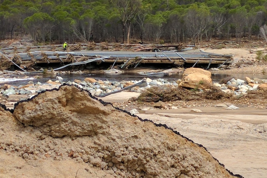 The Phillips River Bridge has broken away from the main road and is covered in debris.