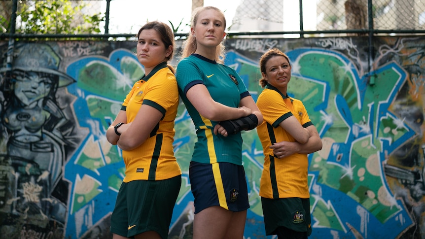 Three members of the ParaMatildas squad stand side by side with their arms crossed for a promotional photo.