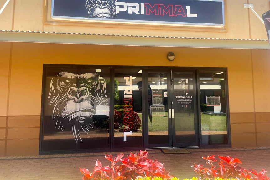 The Primal MMA Gym has black, red and white branding. As angry monkey painting is on the door. 
