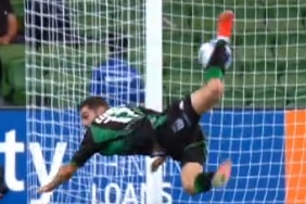 A screenshot of a soccer player flipping in the air to kick a goal.