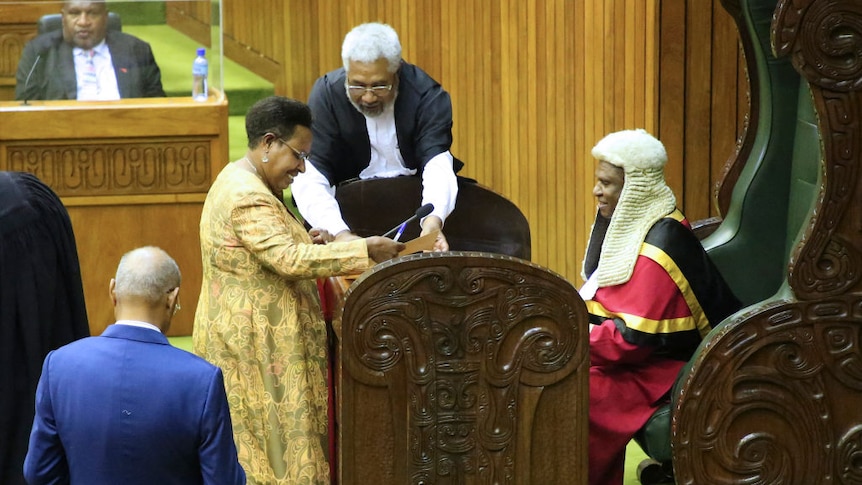 Rufina Peter signs a writ in the PNG Parliament with the bewigged speaker