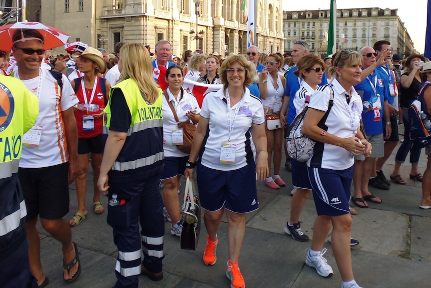 Ildi Vukovich poses among several other people in a square in Turin.