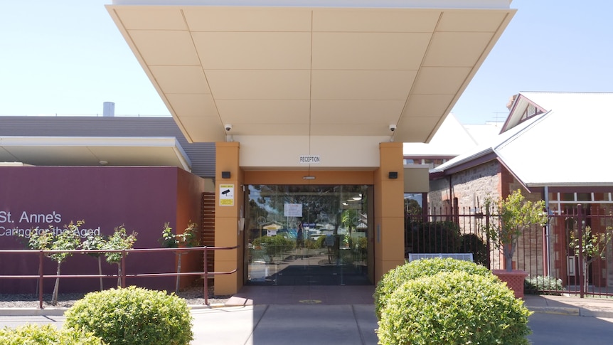 The front of St Anne's Nursing Home, with a crimson building on the left and a roof stretching out over a driveway.