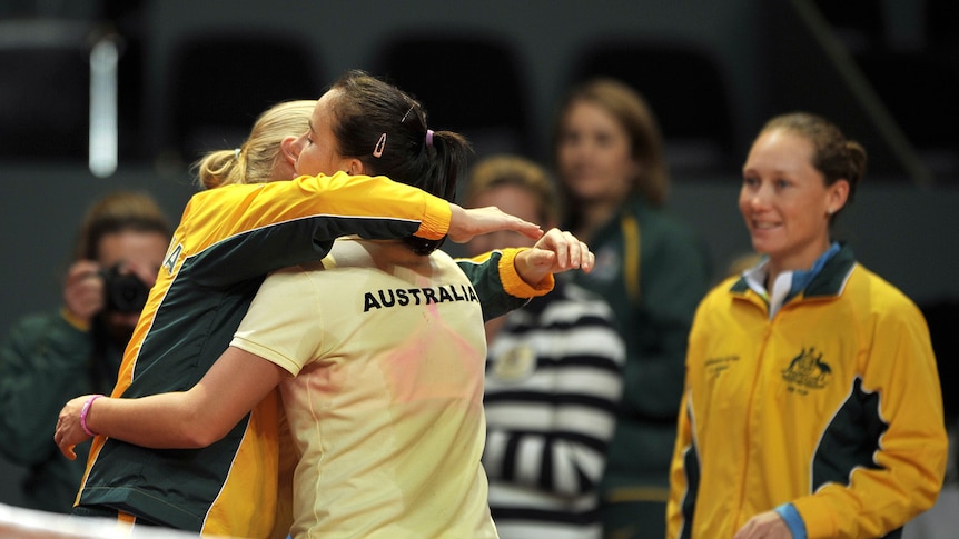 Jarmila Gajdosova is congratulated by Australian team-mates Jelena Dokic and Samantha Stosur.