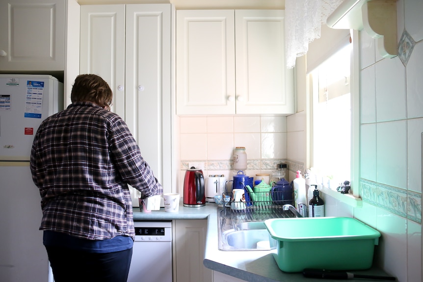 Leo Whittaker prepares a cup of tea in the kitchen of her family's contaminated home.