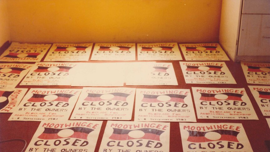 Posters lie on the floor reading 'mootwingee closed by the owners. Blockade for aboriginal ownership. 4-3 September 1983'.