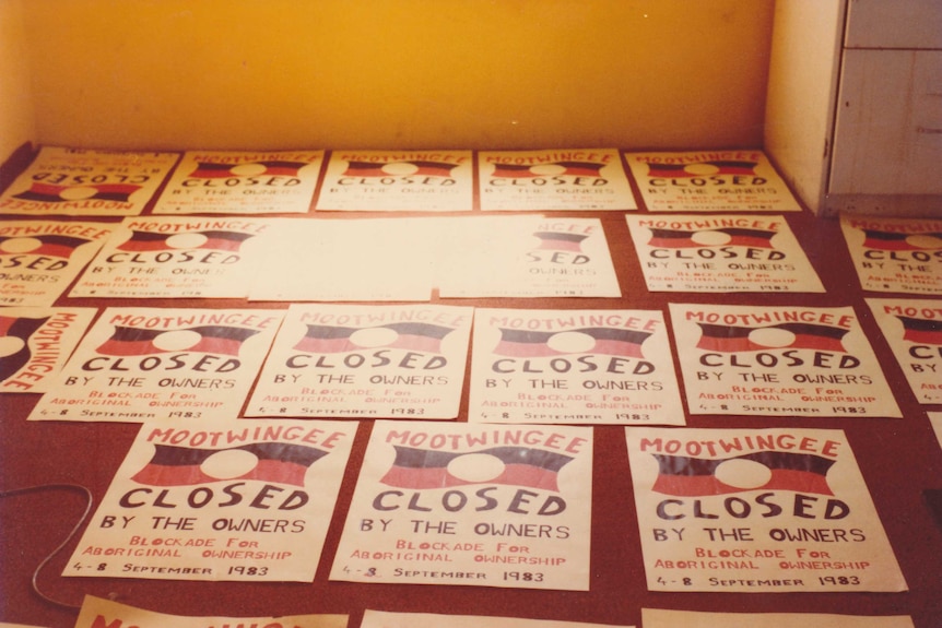 Posters lie on the floor reading 'mootwingee closed by the owners. Blockade for aboriginal ownership. 4-3 September 1983'.