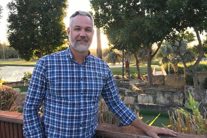 a photo of the director with a golf course in the background