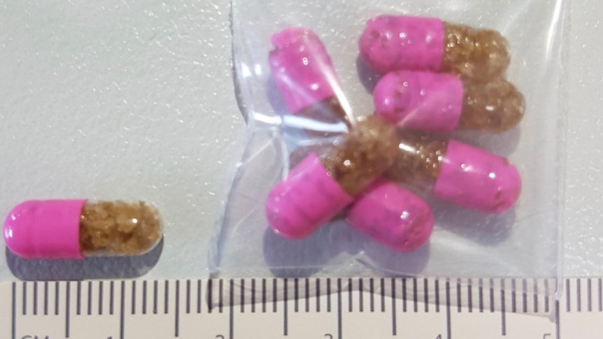 Pink and brown capsules in a plastic bag.