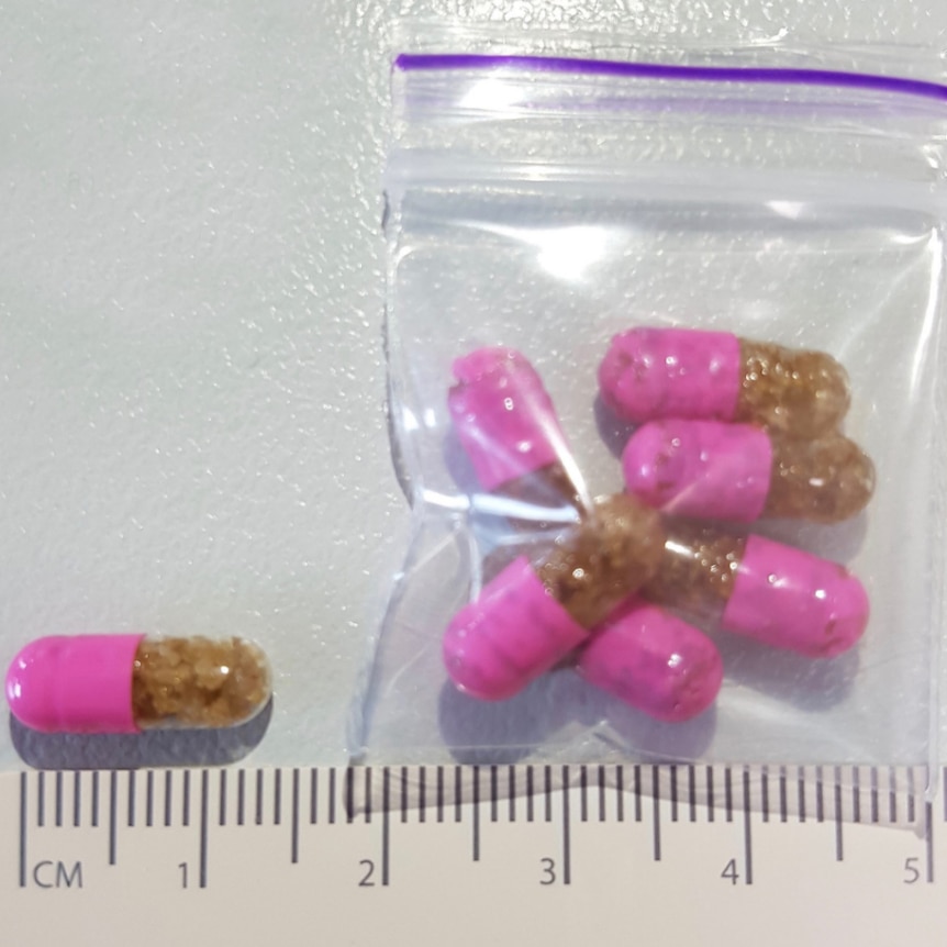 Pink and brown capsules in a plastic bag.