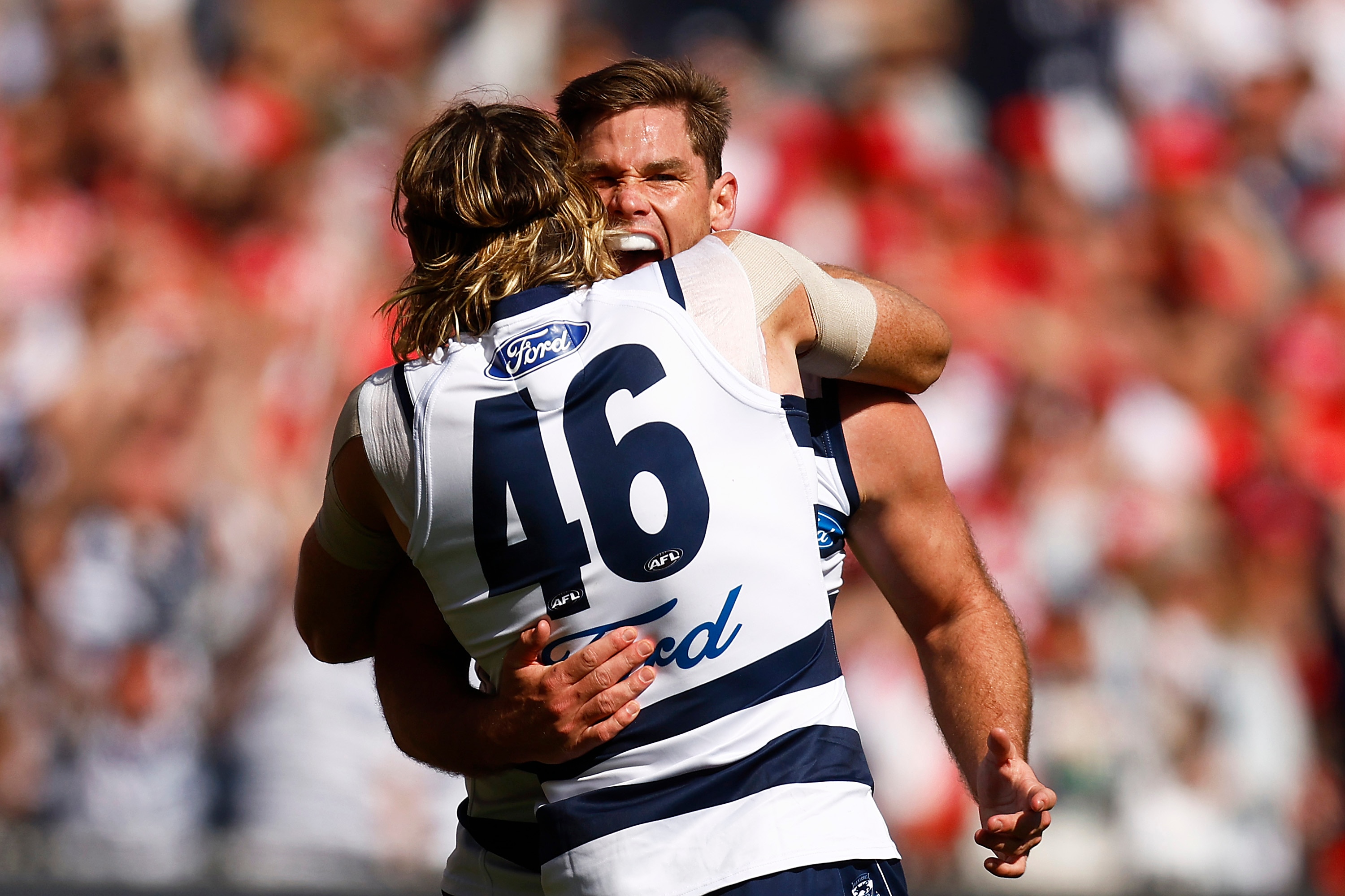 Tom Hawkins and Mark Blicavs embrace after a goal was kicked in the 2022 AFL grand final.