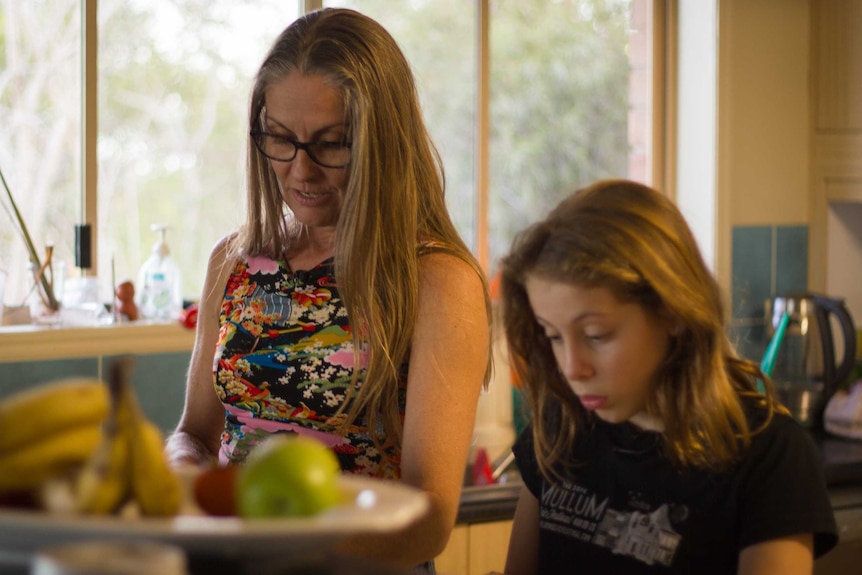 Christine Bromley and her daughter Chilli talk while chopping vegetables in their kitchen