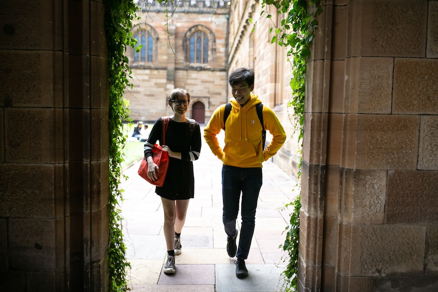 A guy and a girl walk together on a university campus