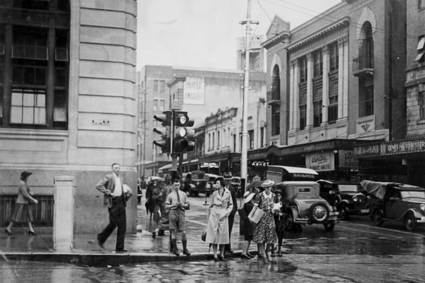 Black and white photo of people waiting to cross Queen and Edward streets