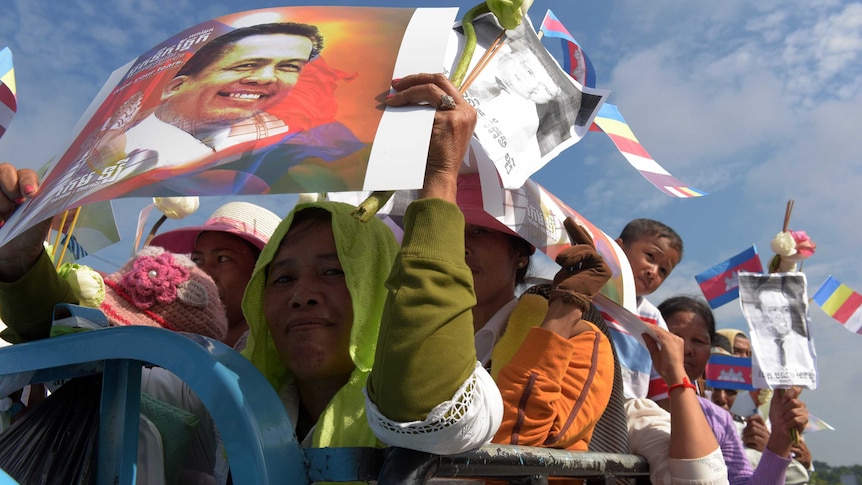 Cambodians hold images of Kem Ley
