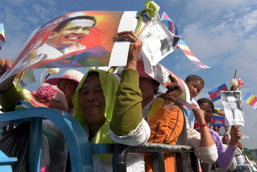 Cambodians hold images of Kem Ley