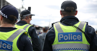 A photo of three unidentifiable Victoria Police officers from behind