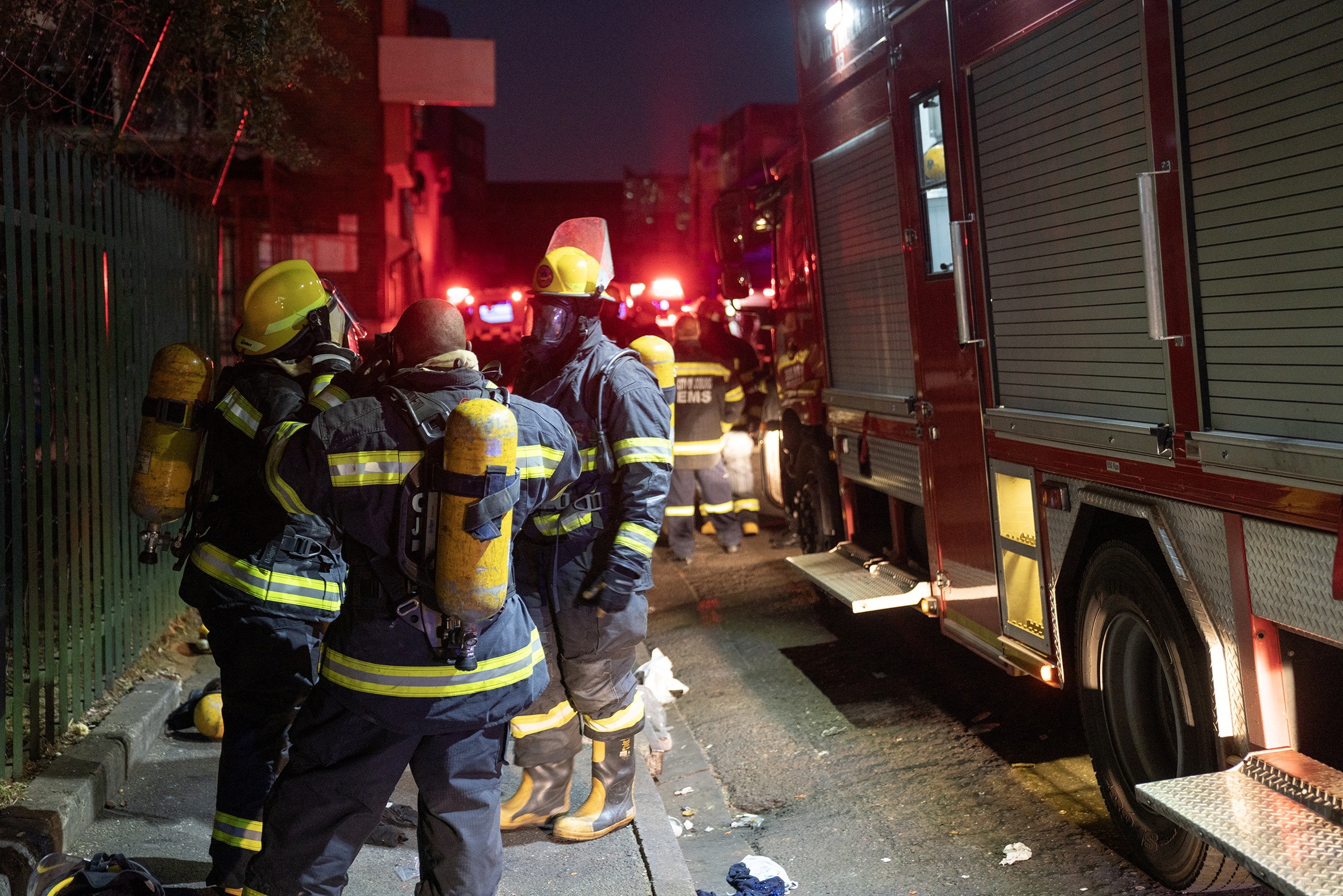 a group of firefighters stand behind a fire truck