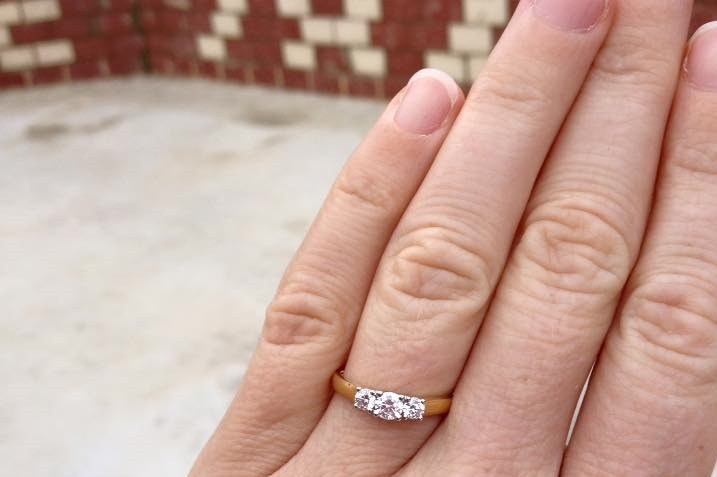 A gold and diamond engagement ring on a woman's finger