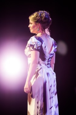 Siobhan Stagg pictured from behind in glowing stage lights.