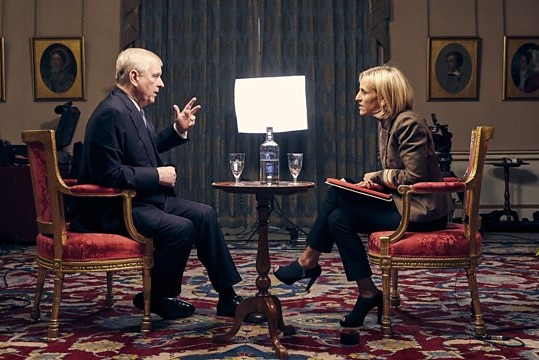 Prince Andrew sits on a chair opposite Emily Maitlis with a film crew in the background.