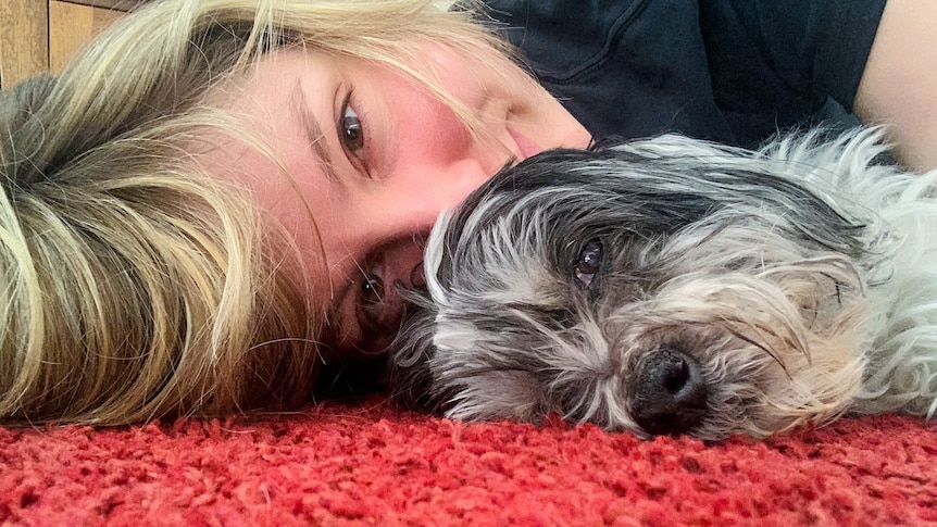 A woman and her pet dog on red carpet