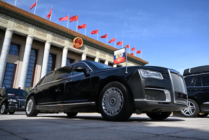 a black limousine in front of China's Great Hall of the People.