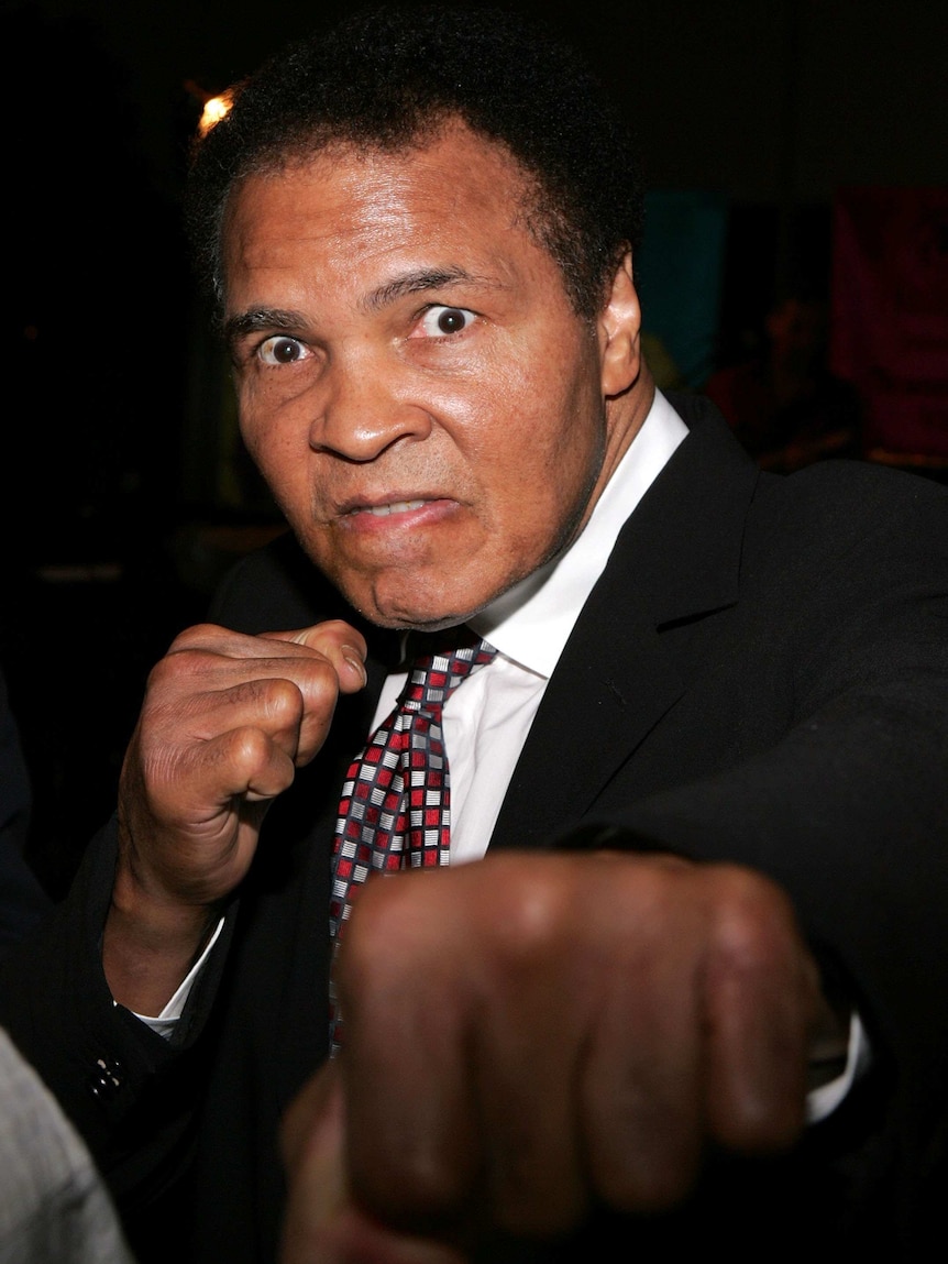 Muhammad Ali poses with a punch