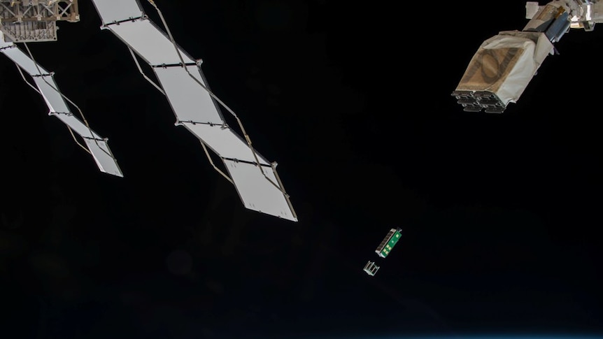 A small  rectangle box floats in space with the earth below it
