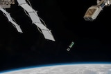 A small  rectangle box floats in space with the earth below it