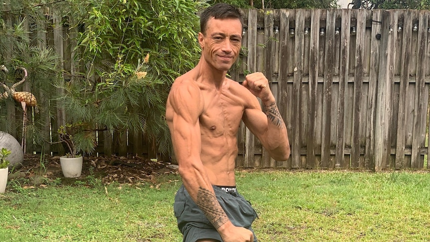 photo of a shirtless man flexing his muscles