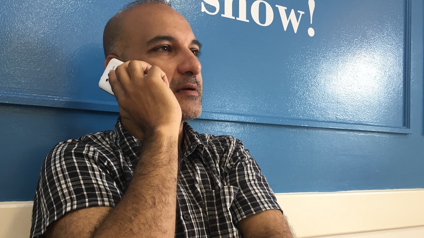 Lawyer Aman Singh takes a phone call leaning against a wall