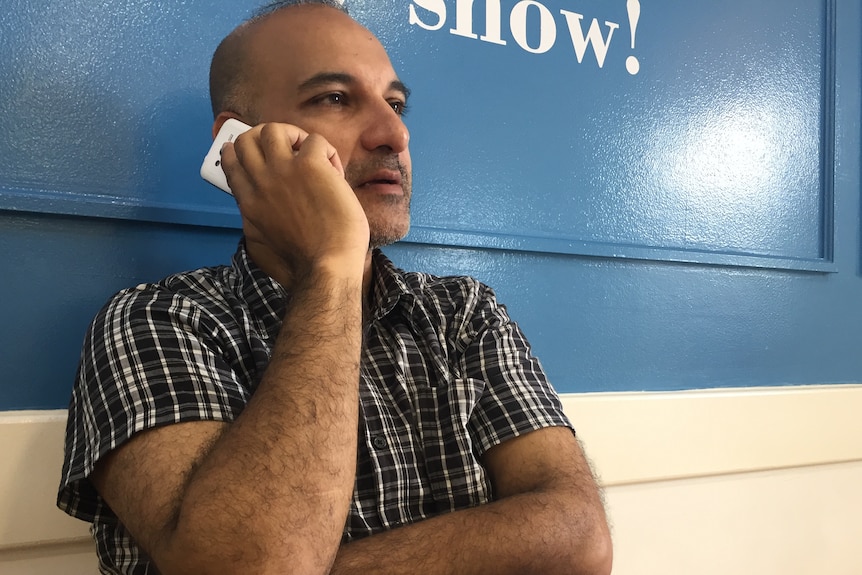 Lawyer Aman Singh takes a phone call leaning against a wall