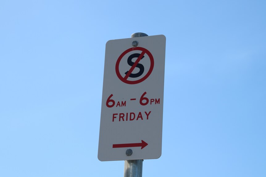 A parking sign showing no standing between 6 am to 6 pm on Fridays 