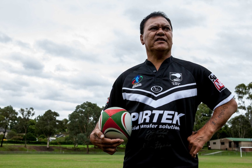Olsen Filipaina standing on a rugby pitch holding a ball and wearing a NZ jersey