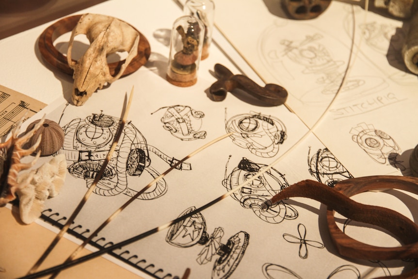 Artist sketches and tools of the trade on a table. 