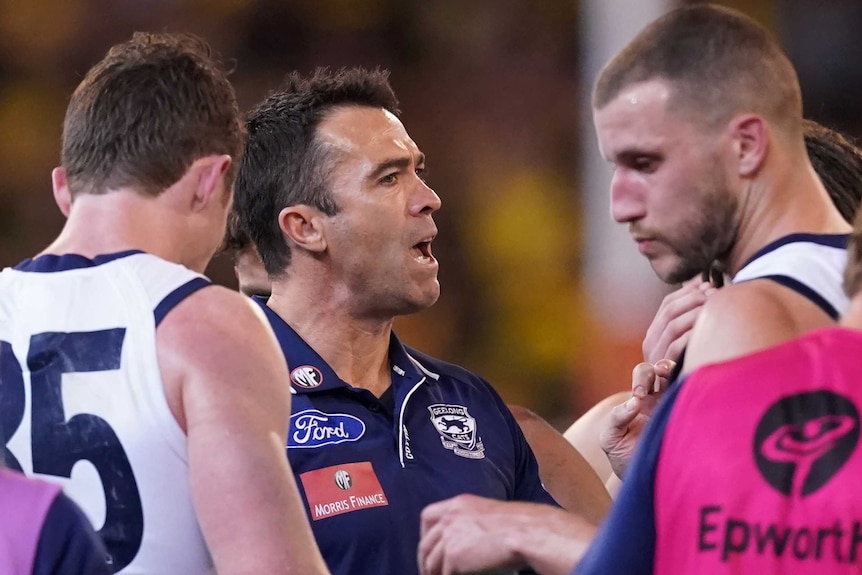 An AFL coach gives his players instructions in a preliminary final at the MCG.