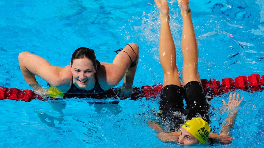 Swimming sisters Cate Campbell and Bronte Campbell happily crossing over the lane rope after a race