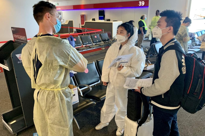 Three people wearing masks