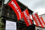 Image of a building with red auction flags waving outside