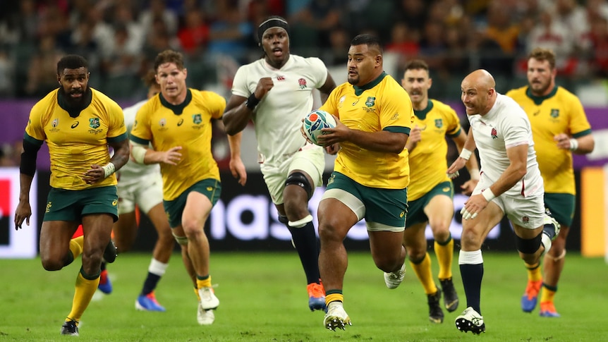 A Wallabies player runs downfield, turning sideways to see his support, as England defenders chase behind him.