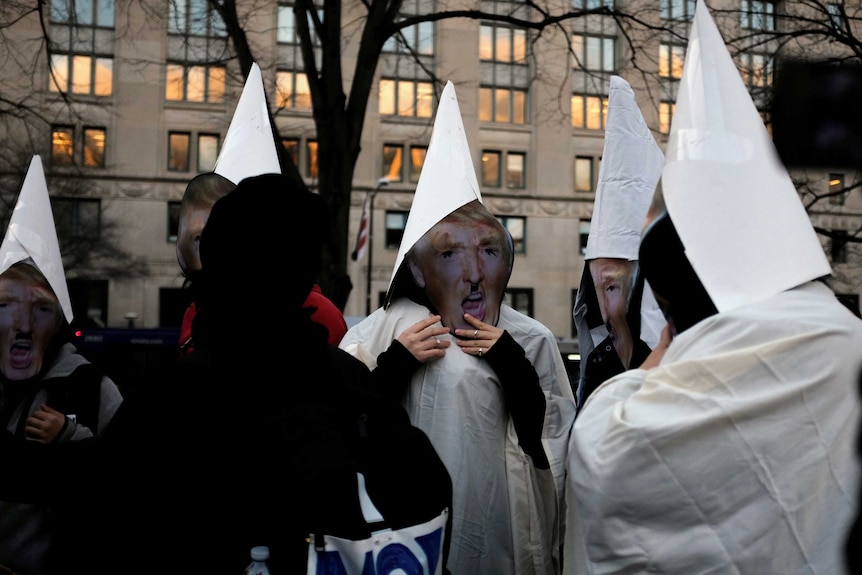 Anti-fascist protesters wearing KKK outfits prepare to descend on the capitol.