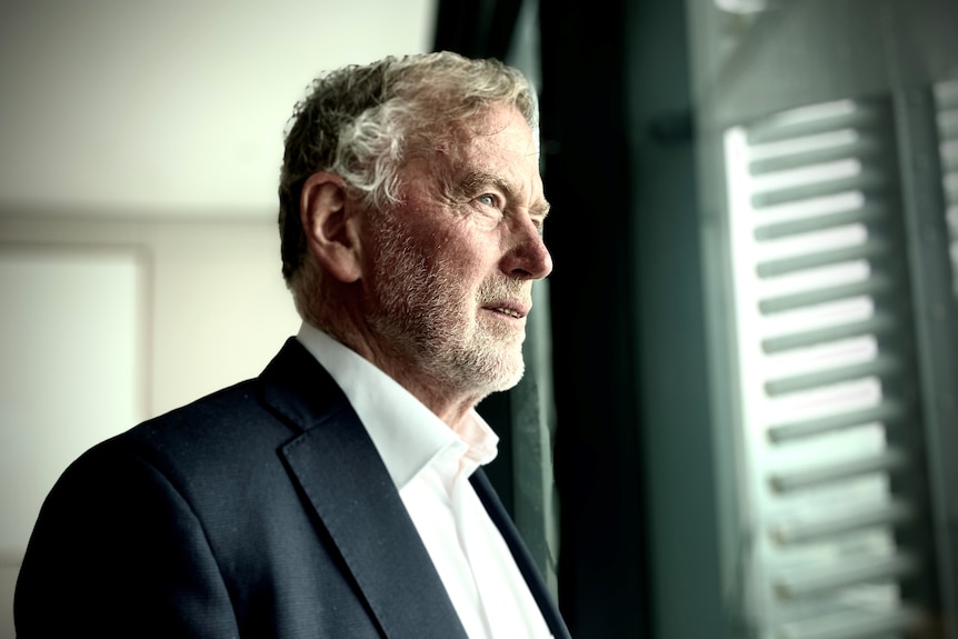 Profile portrait of Danny Gilbert, looking to the right out a window.