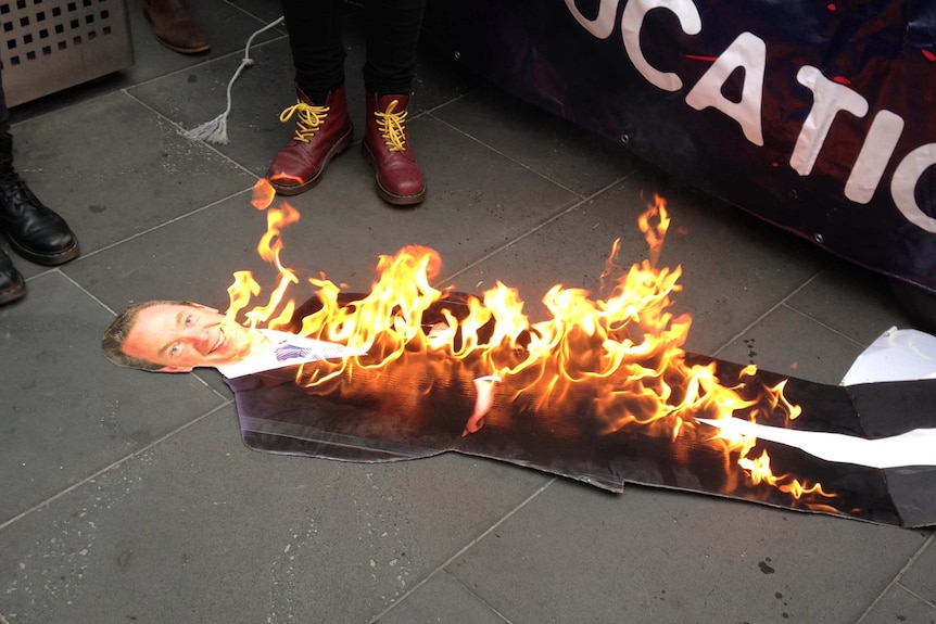 Students in Melbourne burn a cardboard cut out of Education Minister Christopher Pyne.