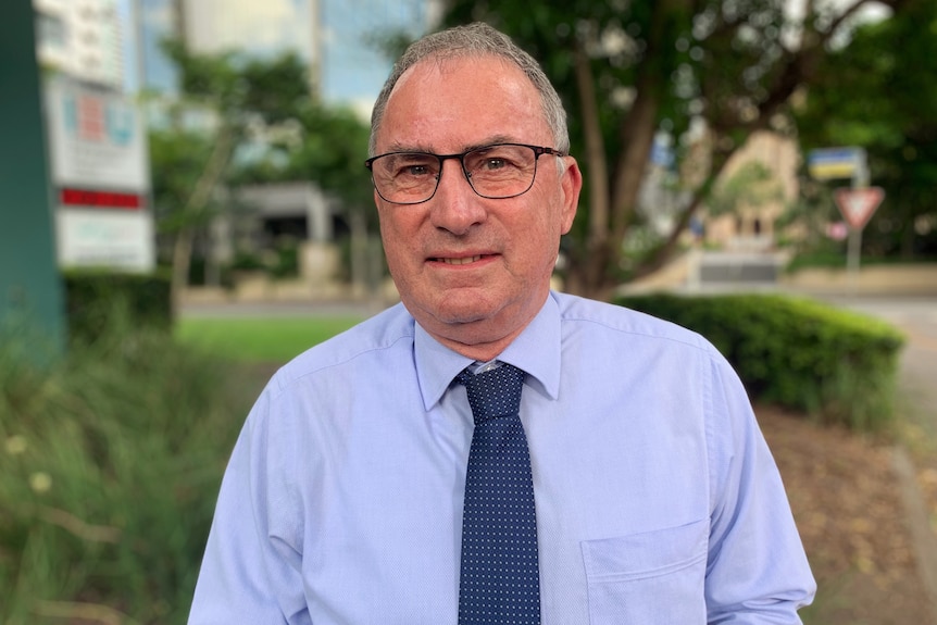 Terry Burke stands outside in a street in Brisbane.