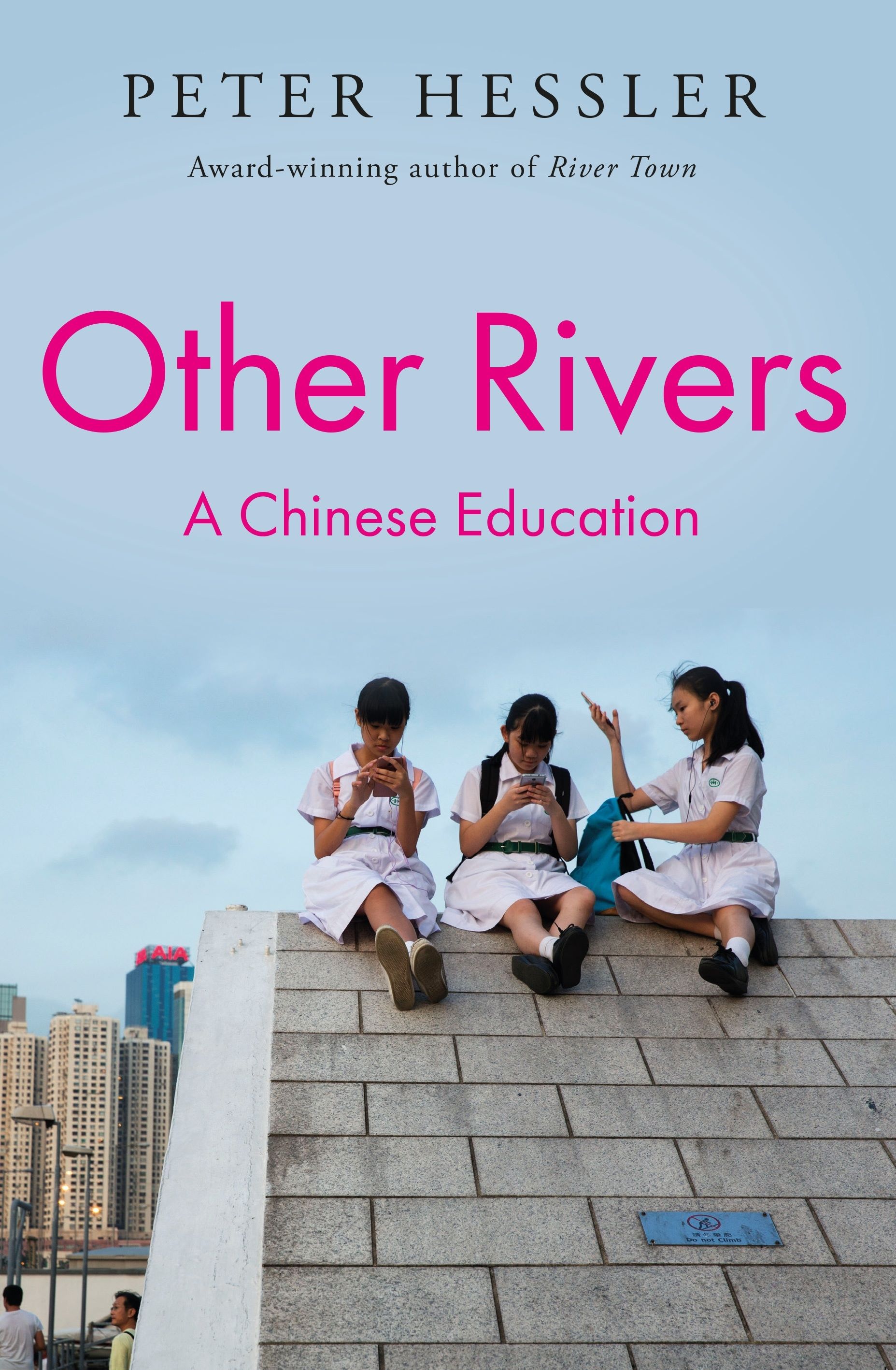 A book cover showing a photograph of three Chinese schoolgirls sitting on the ridge of a concrete roof