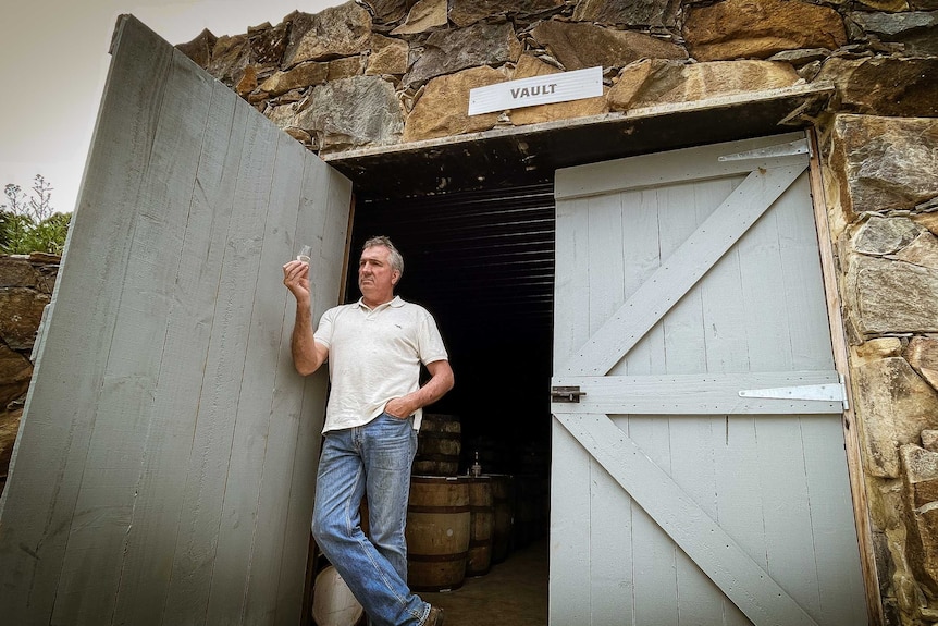 William McHenry of McHenry Distillery holding a glass his Port Arthur shed, Tasmania.