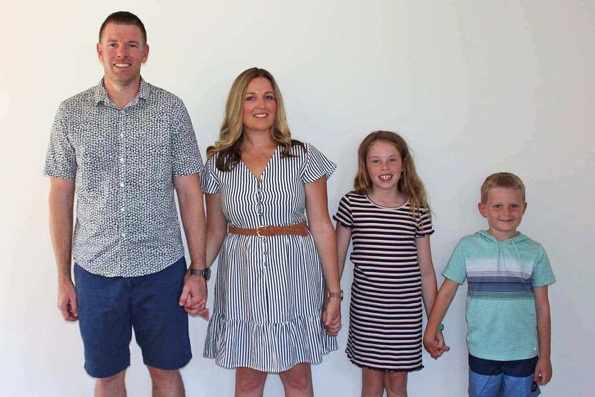 Simon and Tanya Vulinovic and their two children stand in a line.